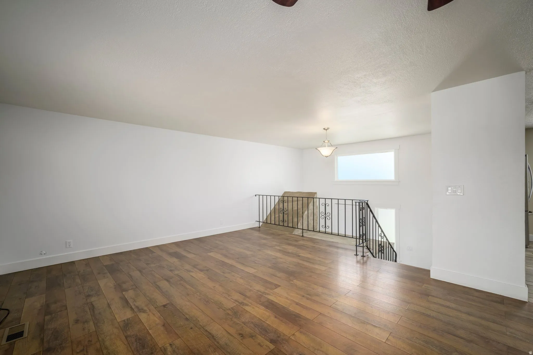 Open-concept living area featuring wood-finish flooring and a white color palette
