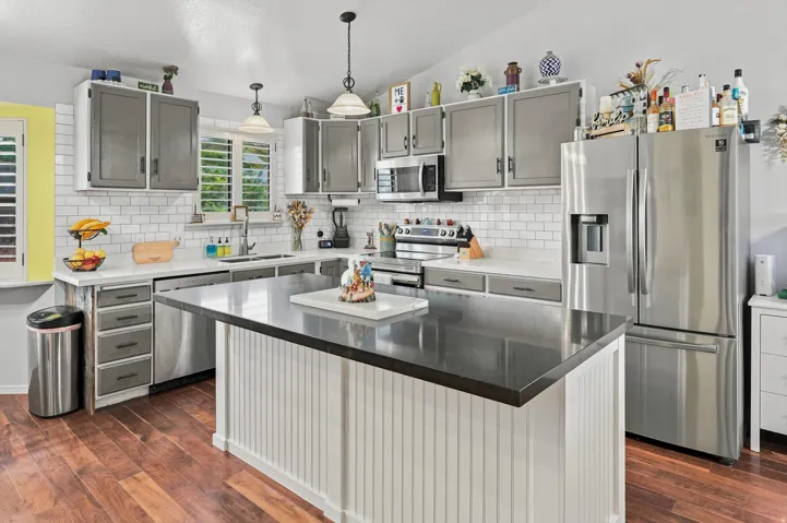 Kitchen featuring a central island with beadboard paneling and a dark countertop