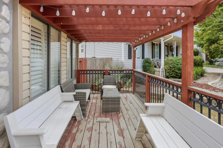 Covered outdoor deck with a wooden pergola featuring string lighting