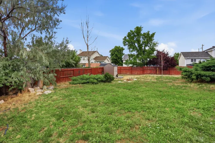 Expansive backyard featuring a natural grass lawn.