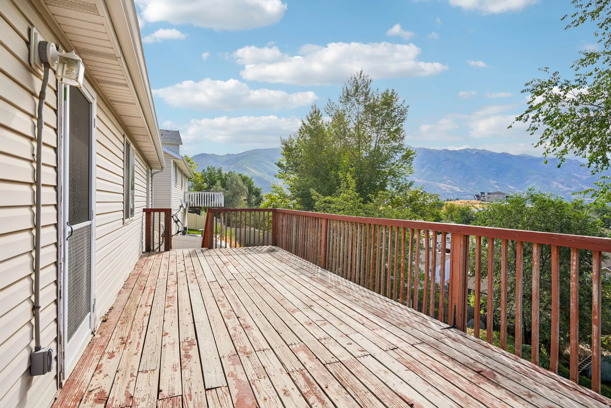 Expansive outdoor deck with wood-finish flooring and railing