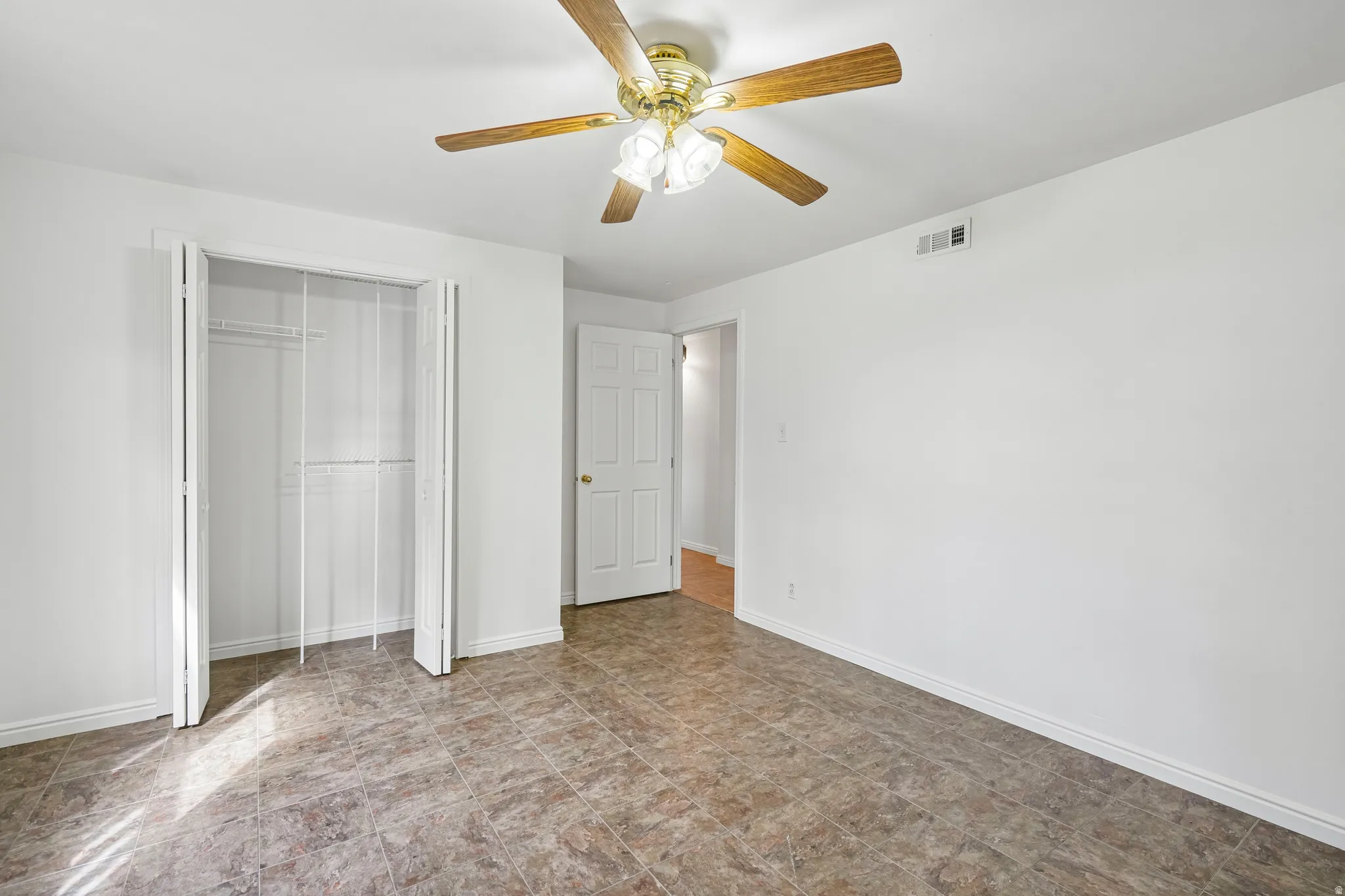 Spacious room with durable tile flooring and crisp white walls