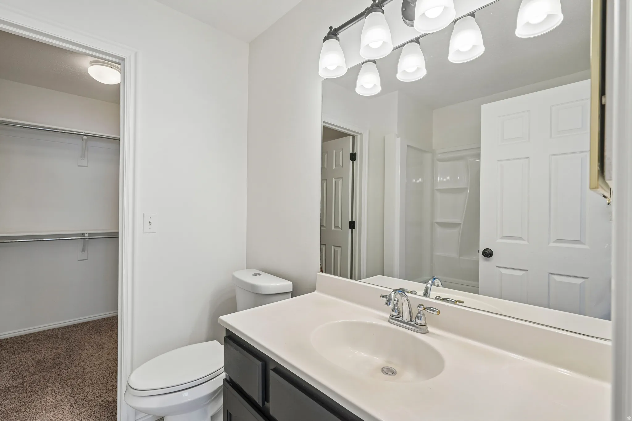 Bathroom vanity featuring a white countertop with an integrated sink and chrome faucet