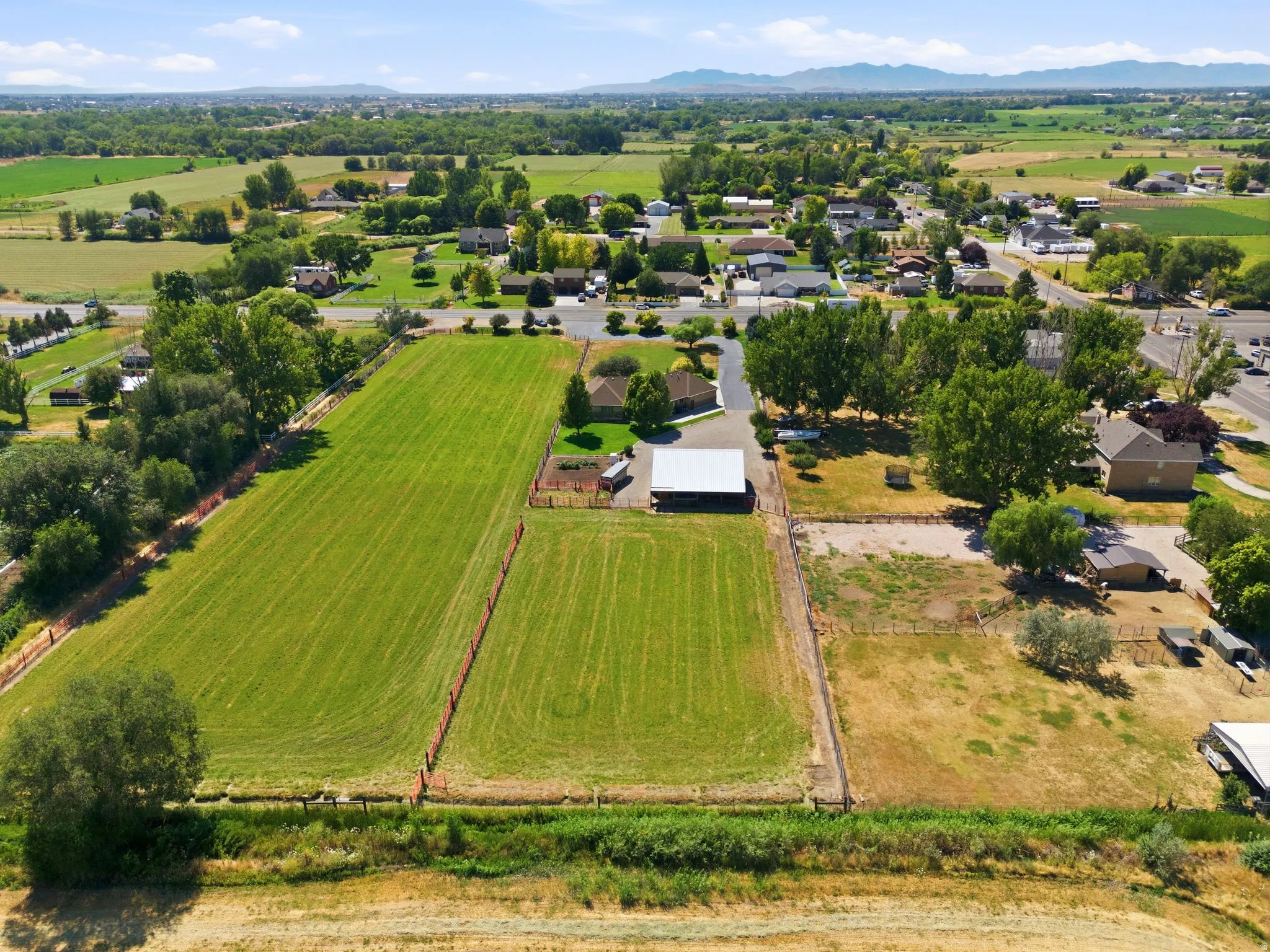 Expansive property featuring significant green space, a residential structure, and a large outbuilding