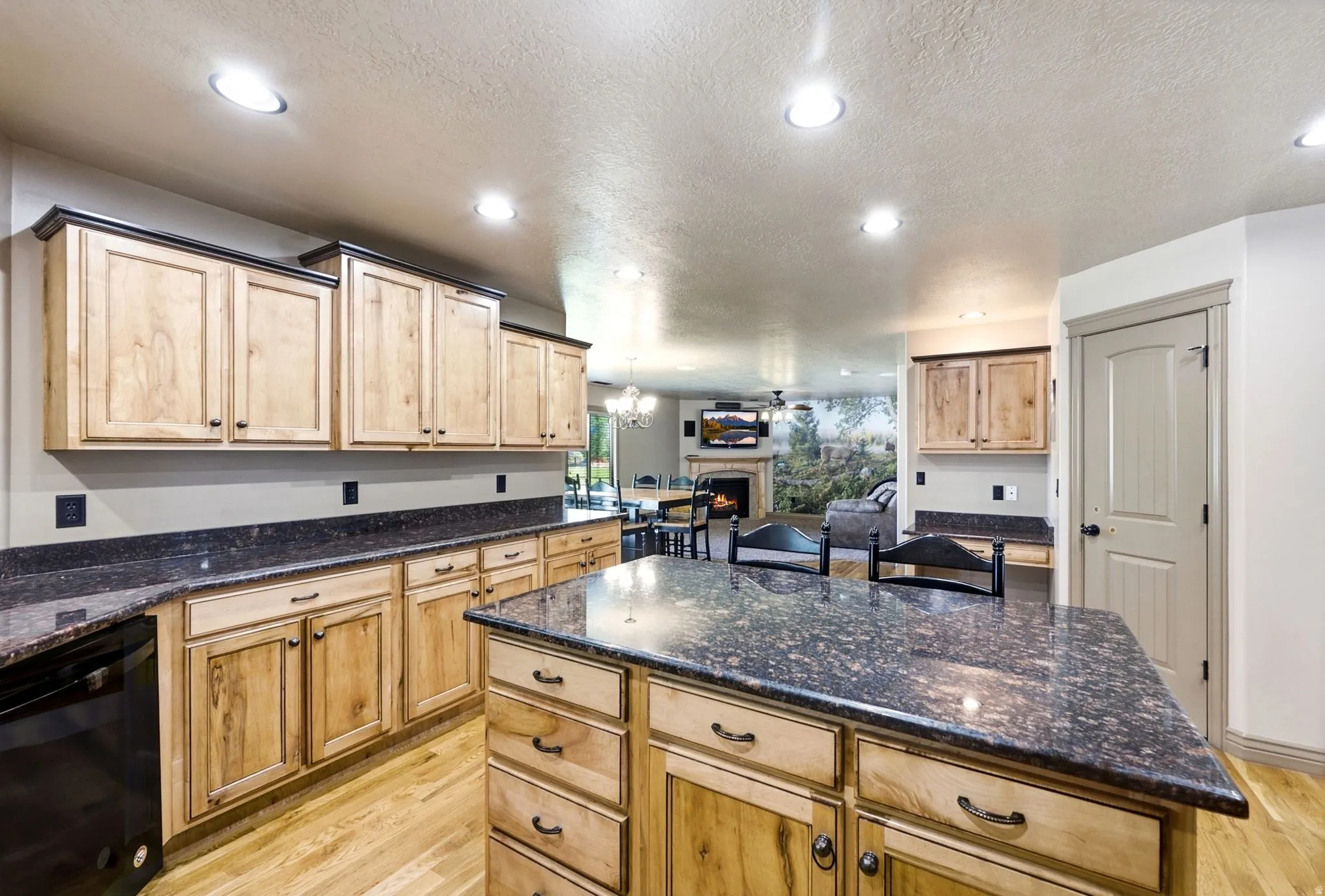 Kitchen featuring wood-finish cabinetry, dark speckled countertops, and recessed lighting