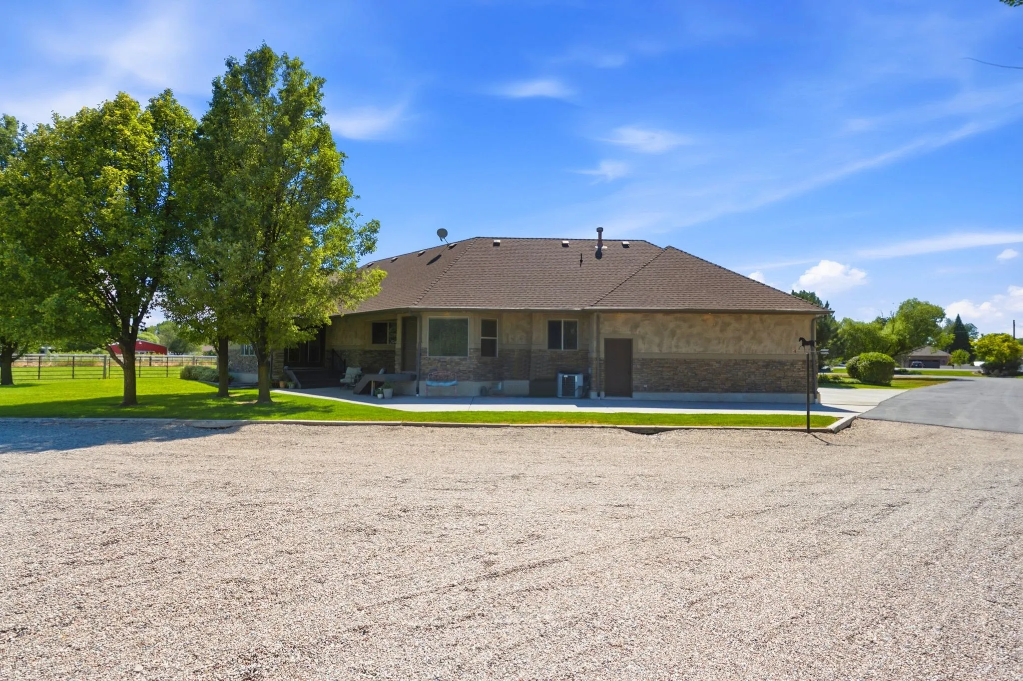 Expansive gravel parking area with a paved driveway
