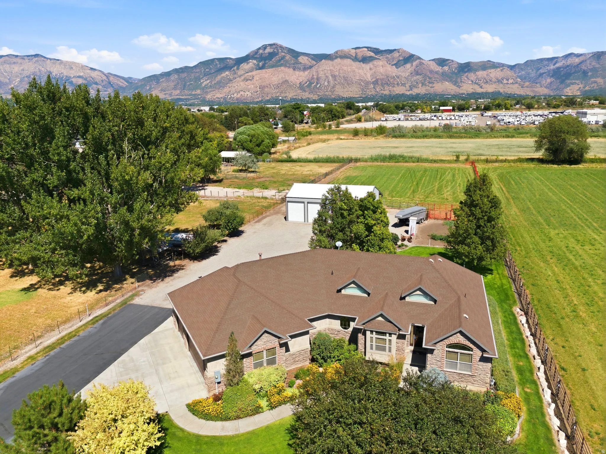 Expansive property featuring a stone and brick exterior residence with a brown shingle roof