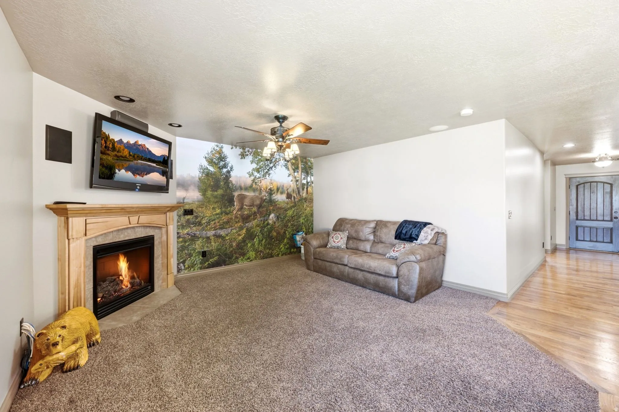 Living area featuring a gas fireplace with a wood-finish mantel and hearth, recessed ceiling lighting, and a ceiling fan
