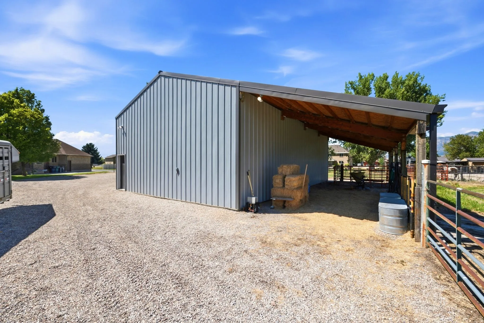 Spacious outbuilding featuring corrugated metal siding and an attached lean-to structure with exposed wood rafters