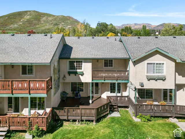 Multiple spacious decks, stucco exterior, and a shingle roof