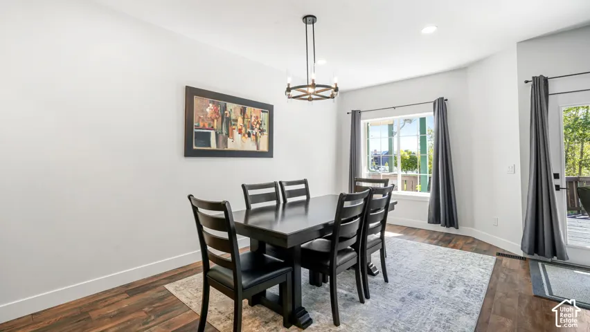 Recessed lighting, wood-finish flooring, a contemporary chandelier, and a glass-paneled door