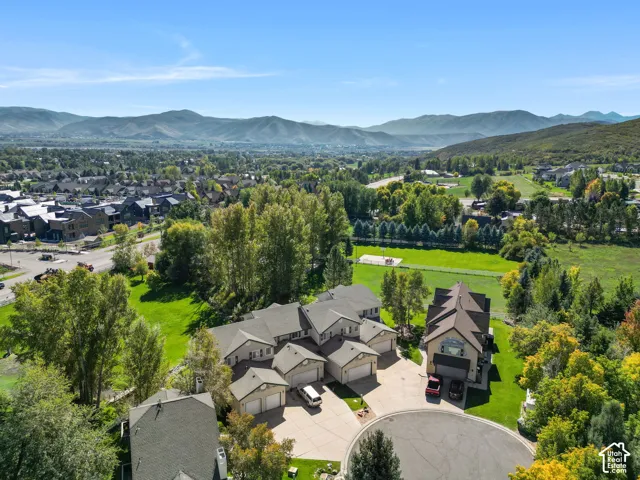 Cul-de-sac location with multi-story dwelling, attached garages, and surrounding green spaces