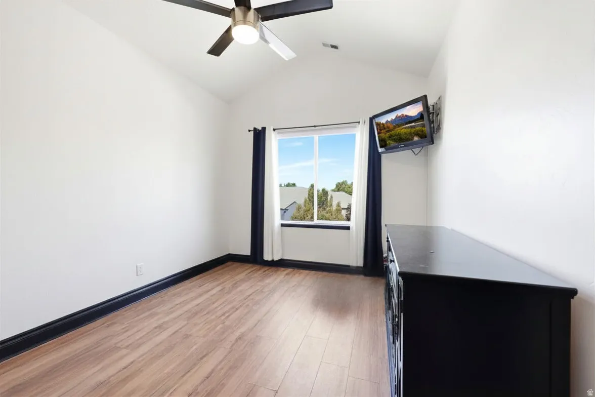 Vaulted ceiling featuring a ceiling fan with light fixture