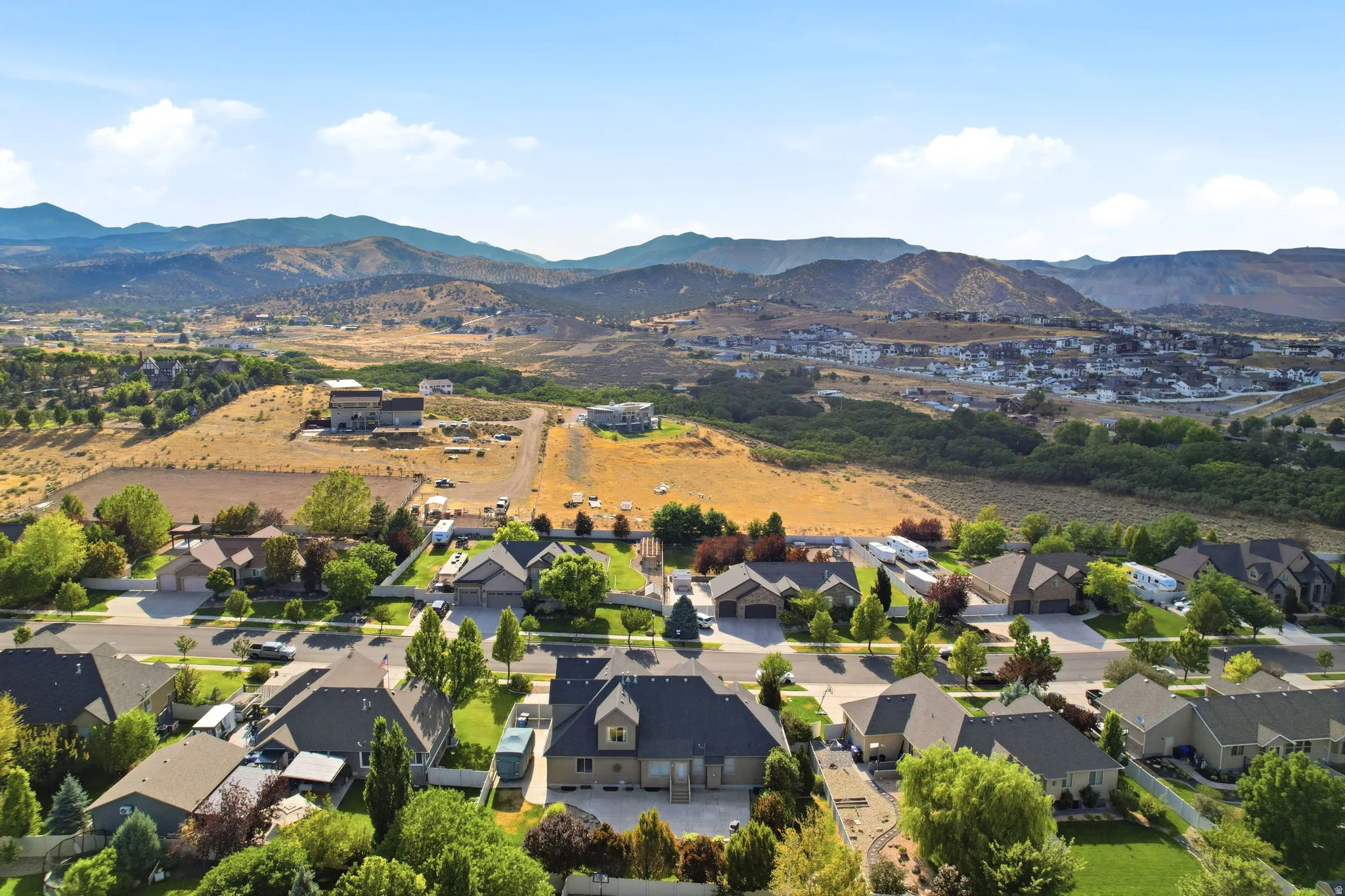 Expansive neighborhood with established residential properties against a backdrop of rolling hills and distant mountains