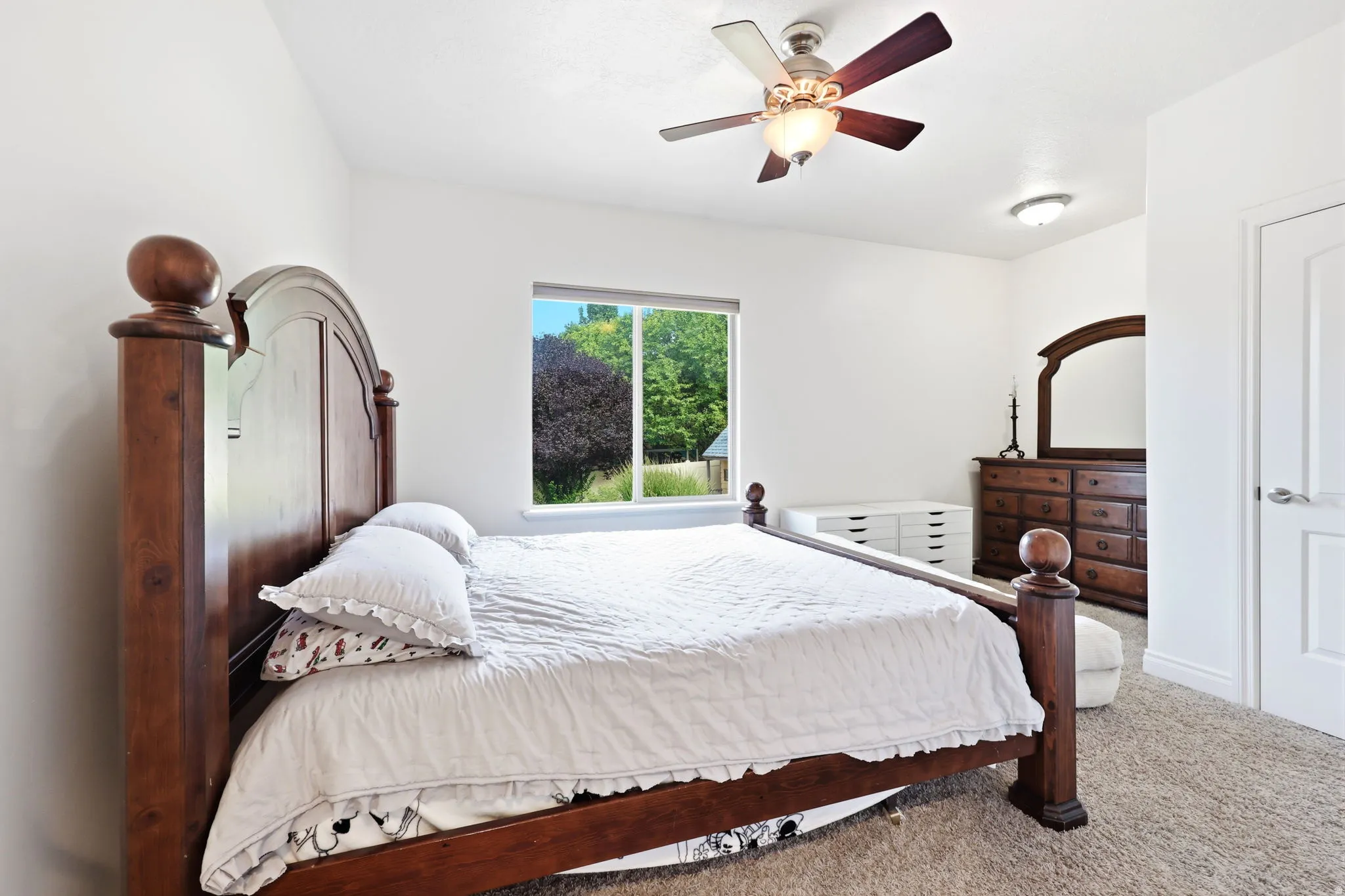 Light-filled room featuring a broad window, neutral-toned wall paint, ceiling fan with integrated lighting, recessed lighting, and carpet flooring