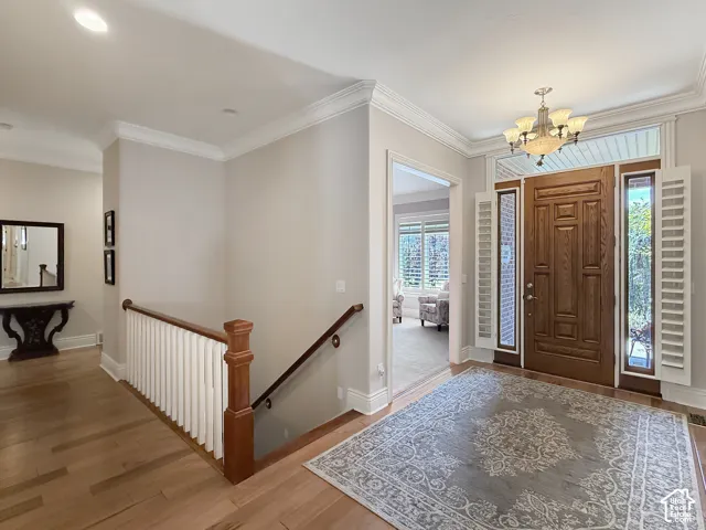 Foyer with natural light, hardwood flooring and crown molding.