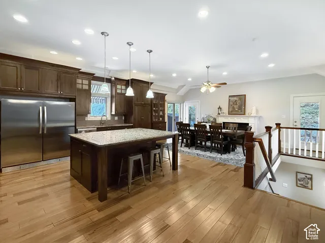 Granite countertops, stainless steel refrigerator, kitchen bar, hardwood flooring