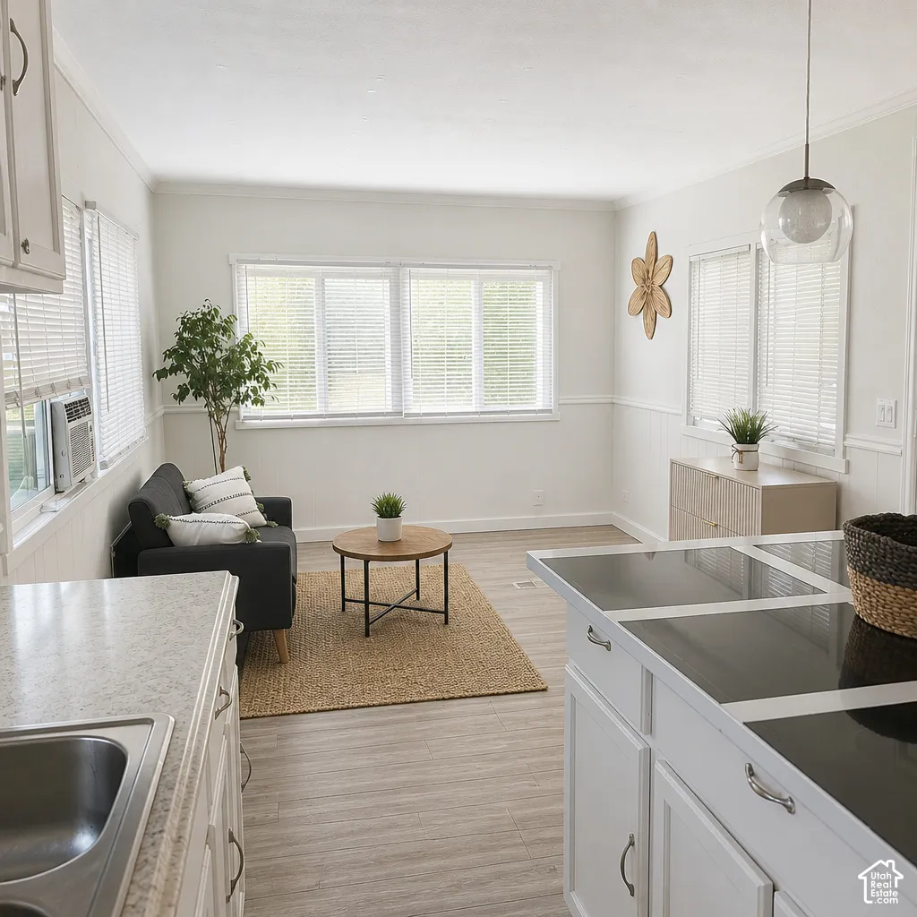 Open concept living space featuring wood-finish flooring, white paneled walls, and multiple windows