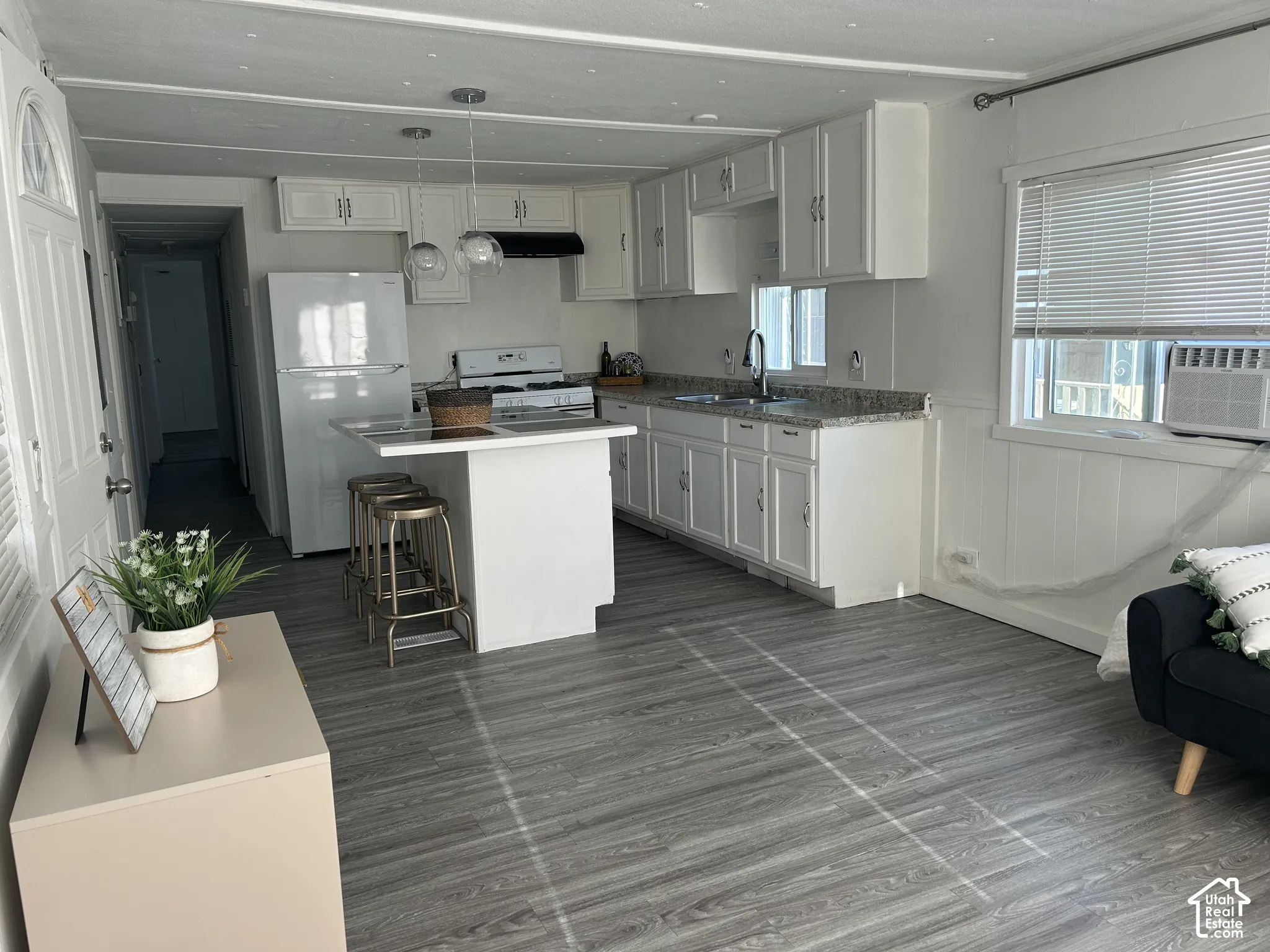 Open-concept kitchen featuring white cabinetry and a central island with bar seating.