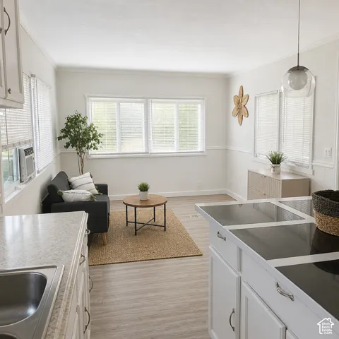 Open concept living space featuring wood-finish flooring, white paneled walls, and multiple windows