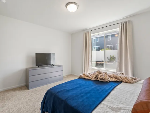 Bright interior space with neutral wall tones and a large window with drapes