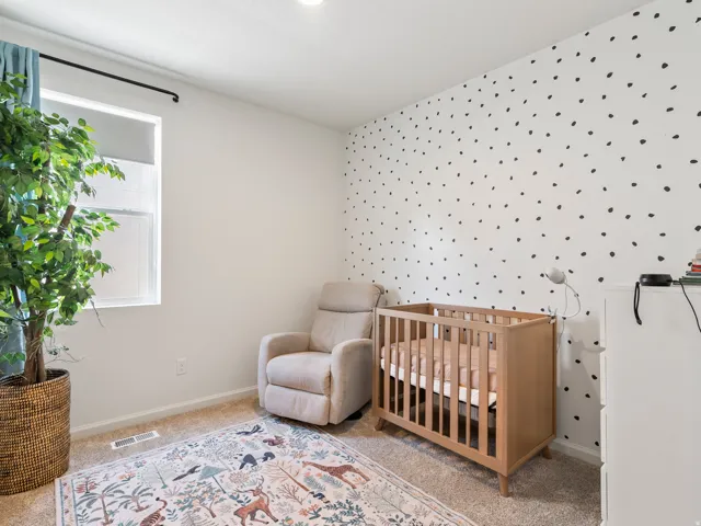 Bright room with white walls, one featuring a decorative black dot pattern