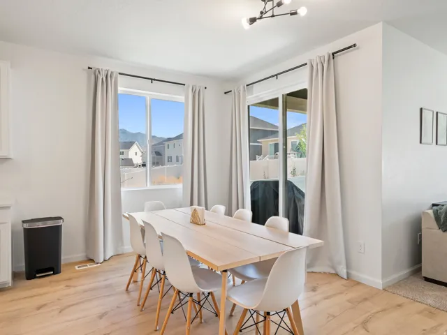 Bright dining area featuring wood-finish flooring, a large picture window, and a sliding glass door