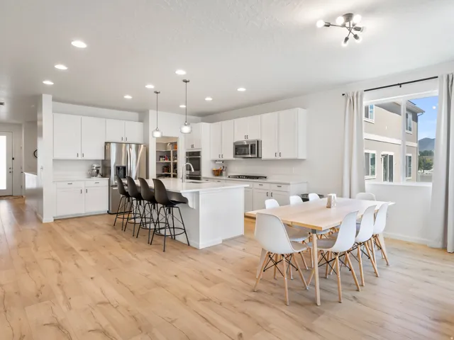Open-concept kitchen and dining area featuring light wood-finish flooring