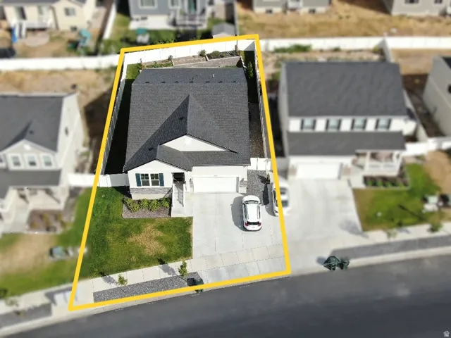 Contemporary residence featuring an attached garage, paved driveway, and established front landscaping