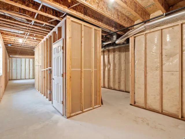 Unfinished interior space featuring exposed wood framing, concrete flooring, insulated walls, and visible ductwork