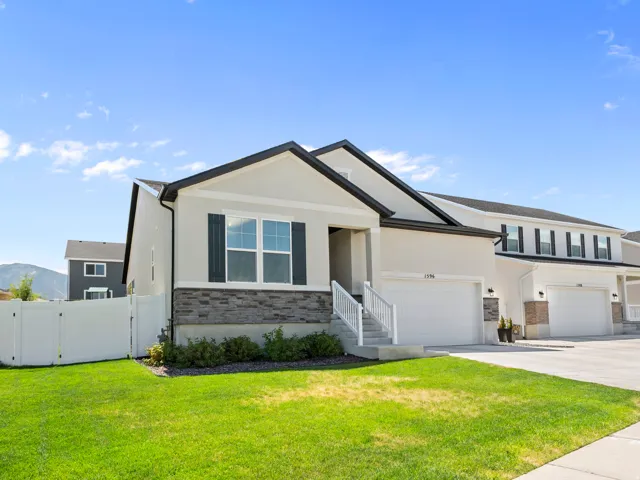 Contemporary stucco exterior with a dark-pitched roofline and stone accent facade