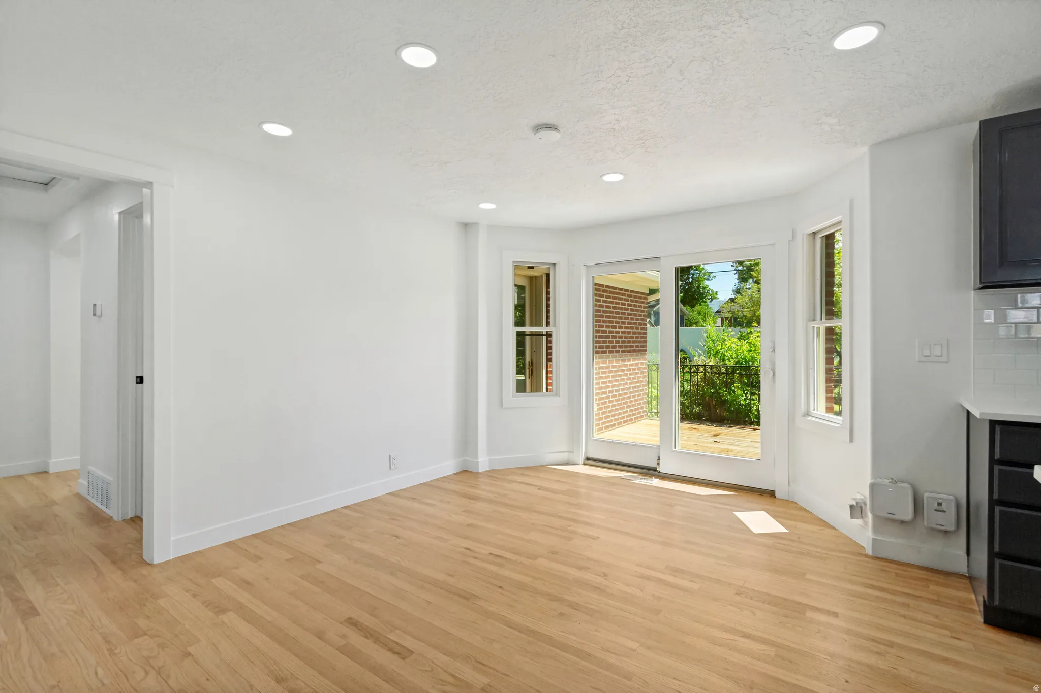 Hardwood-finish flooring throughout, featuring a bay window with a sliding glass door
