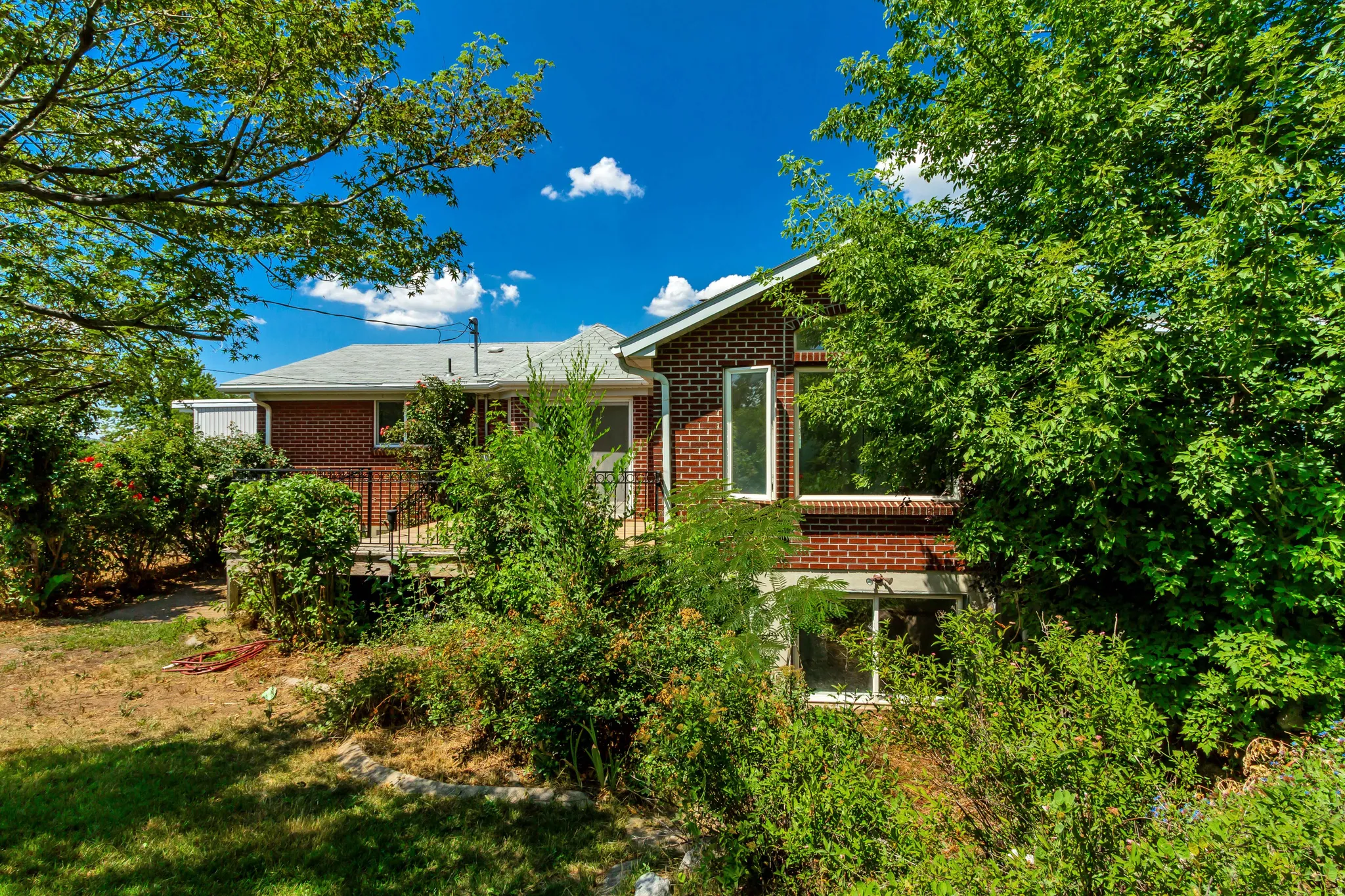 Brick exterior with a multi-level deck featuring dark railings