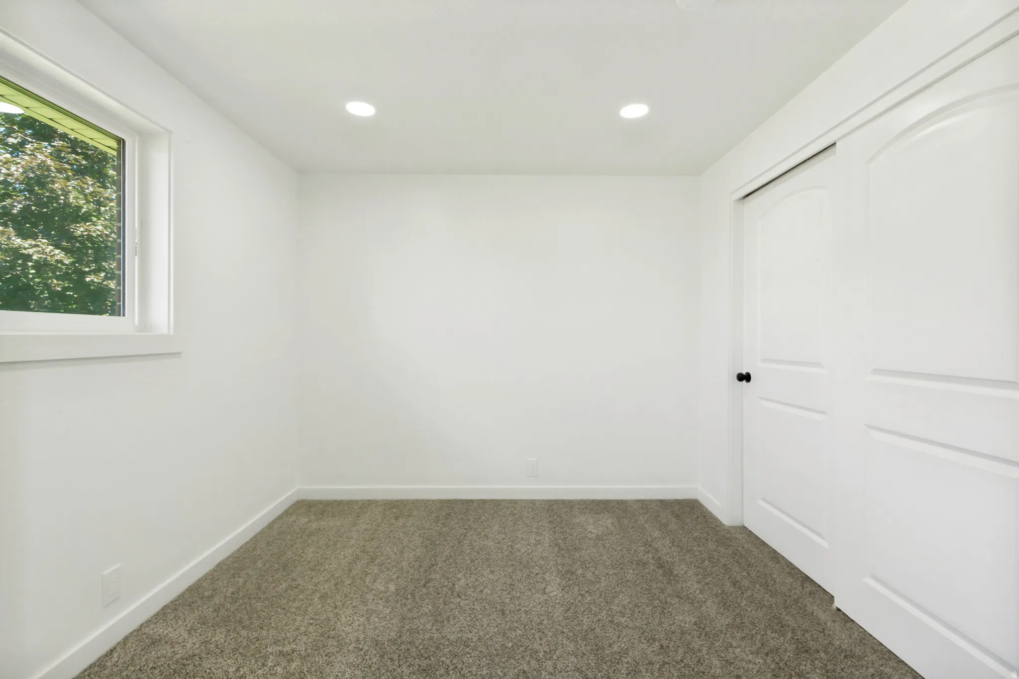 Room featuring plush gray carpeting, white walls, and a recessed lighting fixture