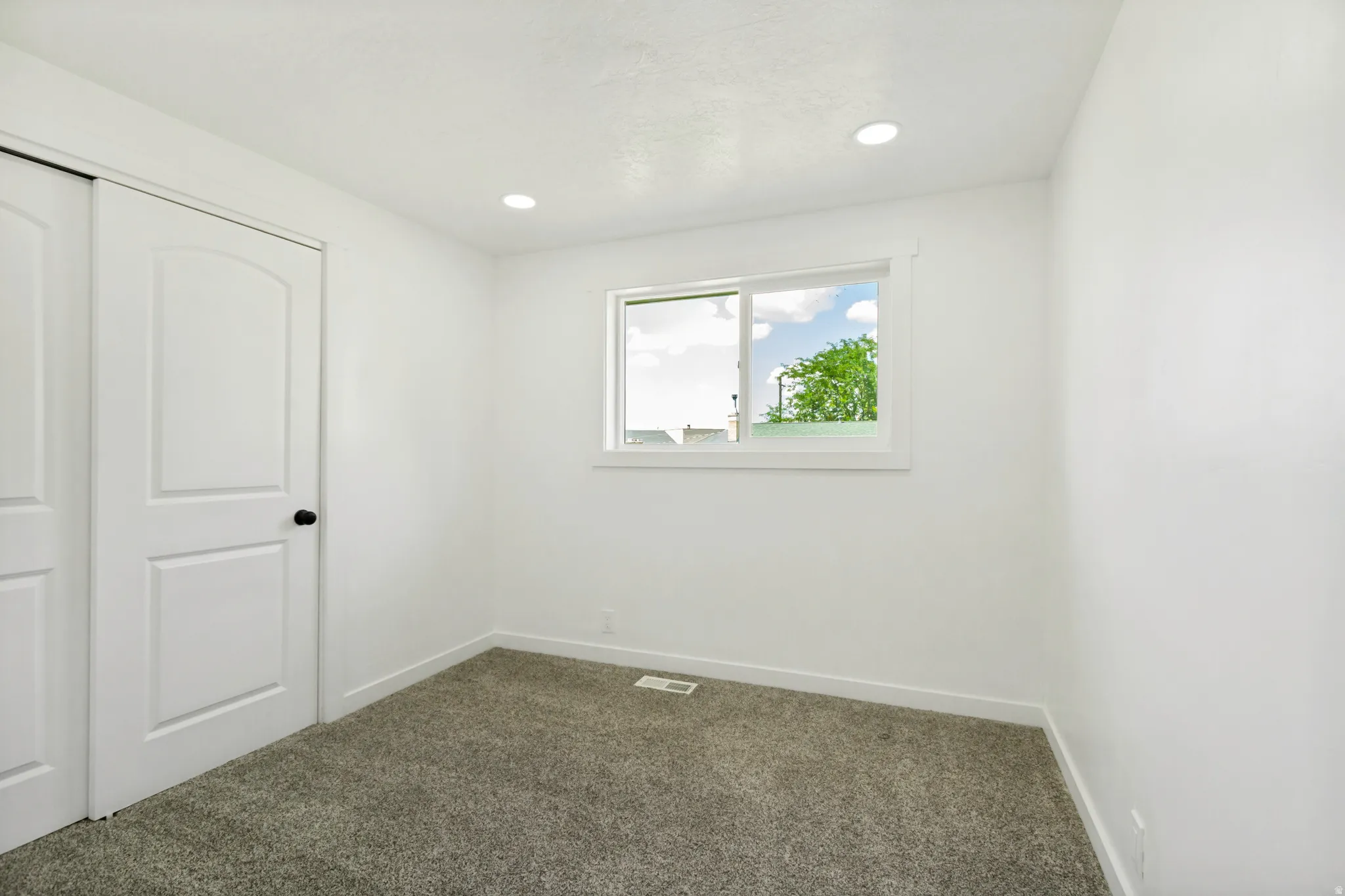 Room featuring white walls and grey carpet flooring