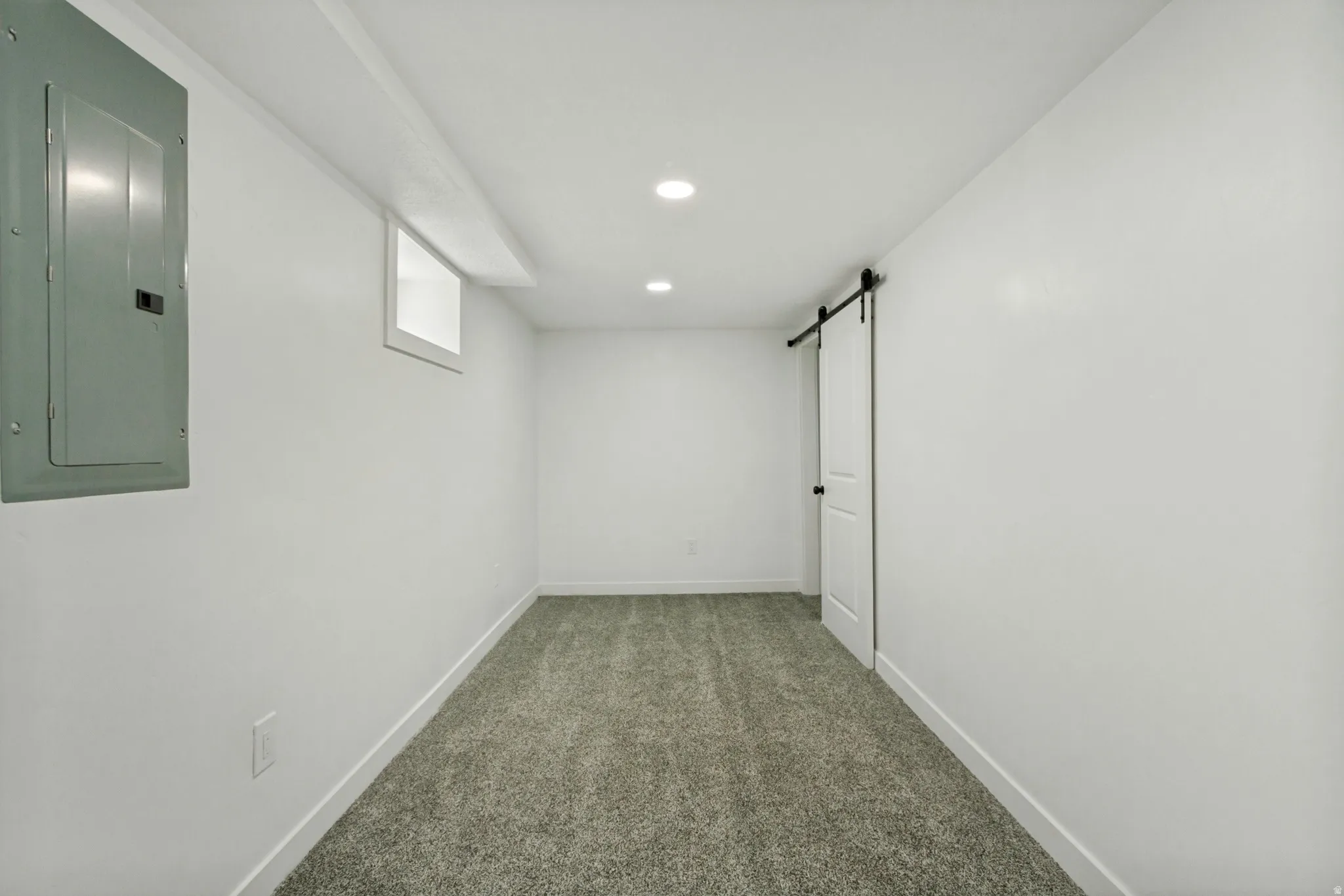 Finished room featuring recessed lighting, a sliding barn door, and carpet flooring