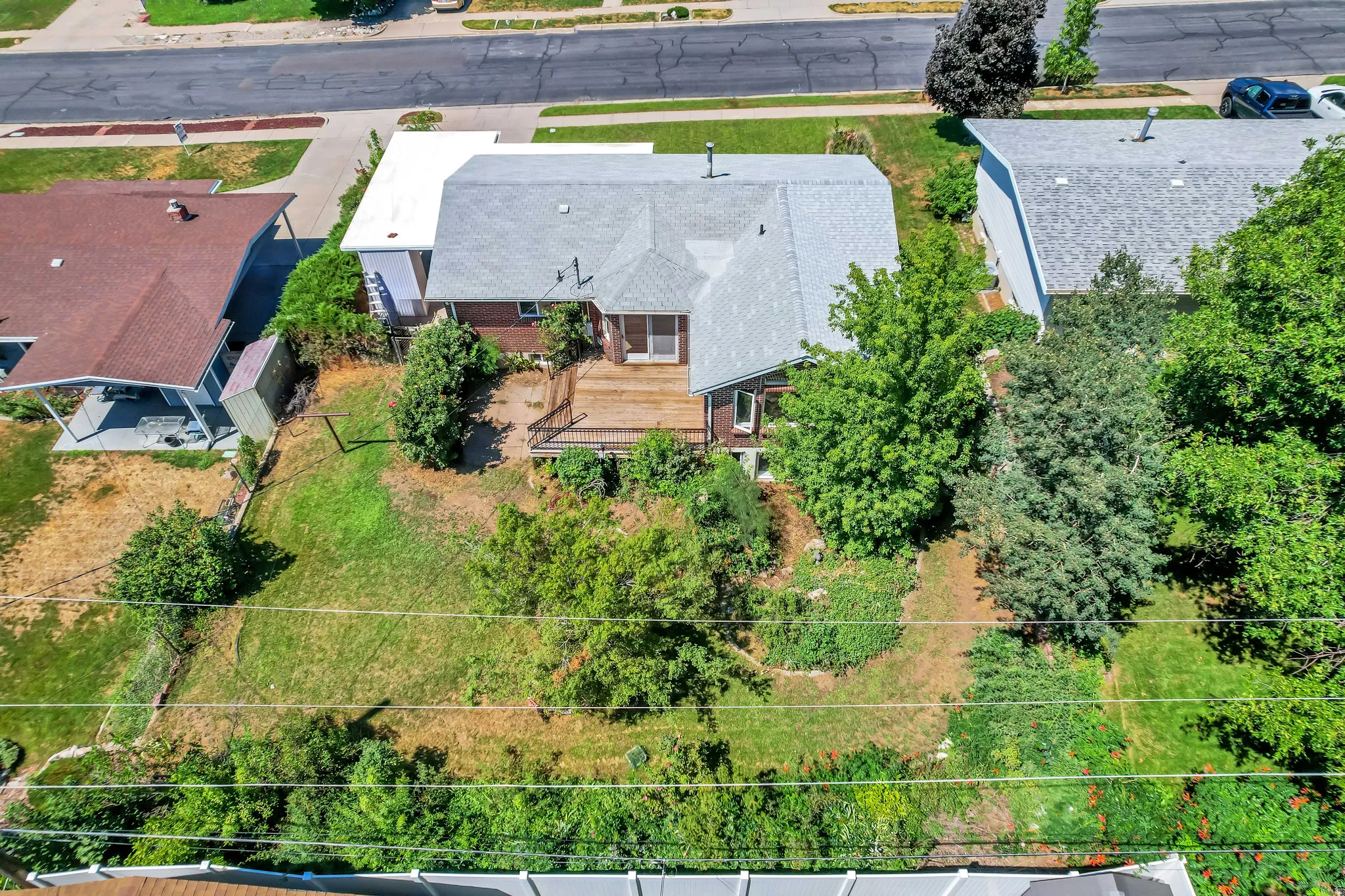 Expansive backyard featuring a multi-level wood deck, mature trees, and landscaping