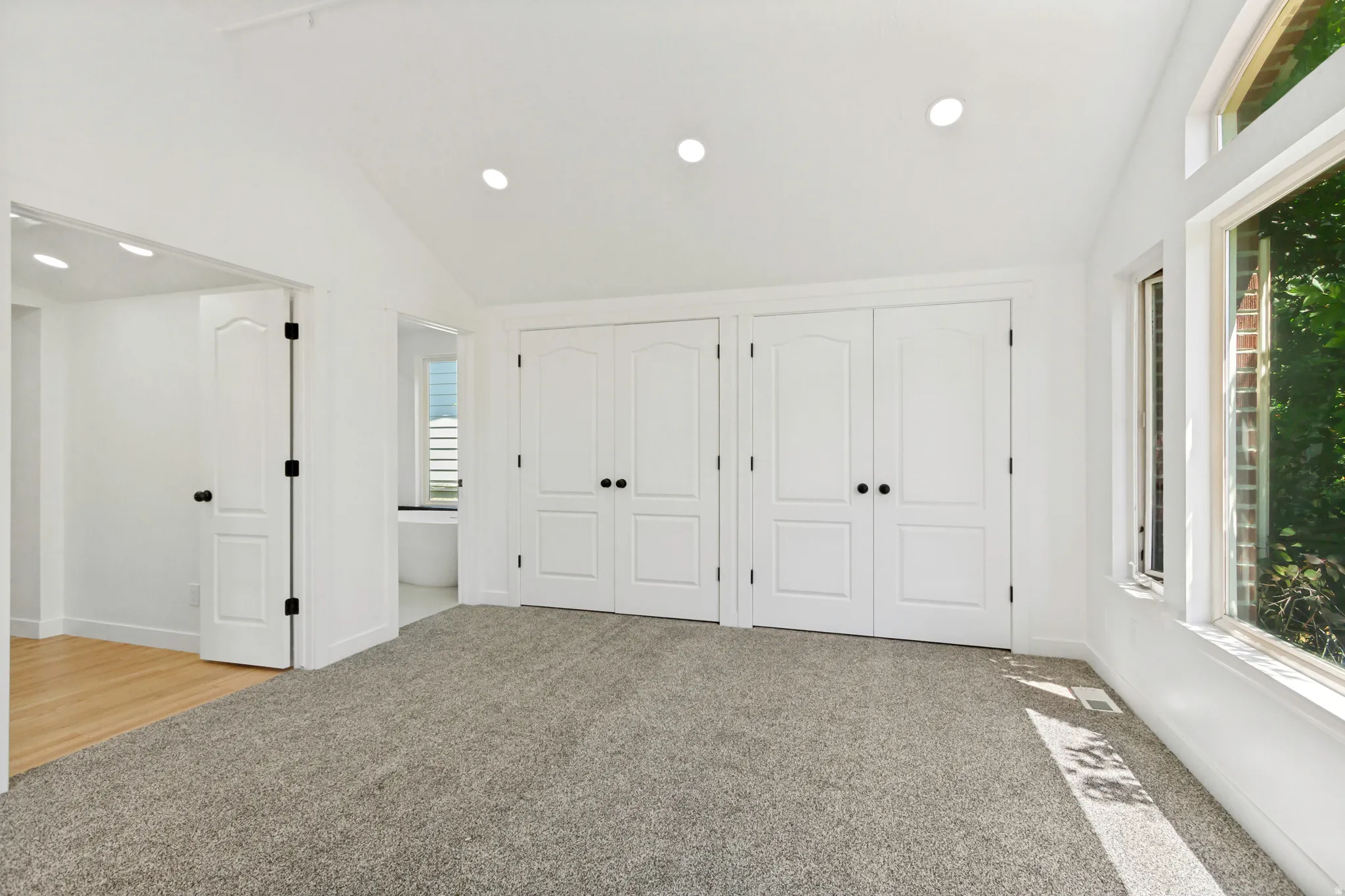 Bright room featuring a vaulted ceiling with recessed lighting