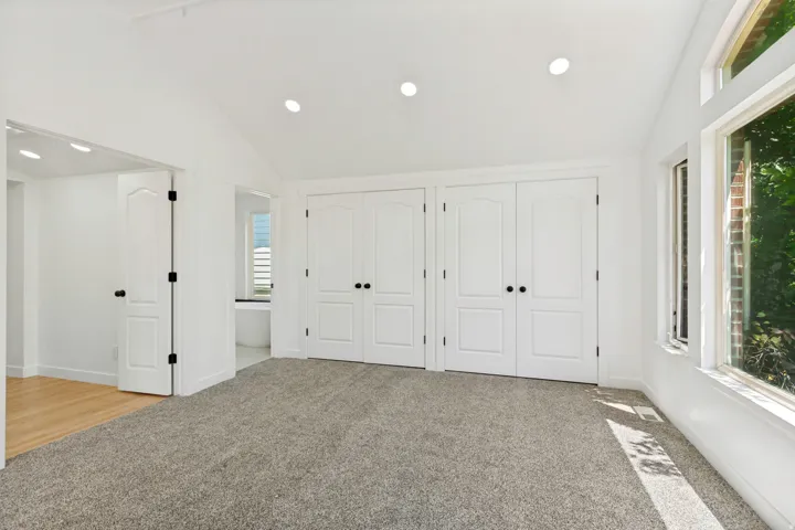 Bright room featuring a vaulted ceiling with recessed lighting