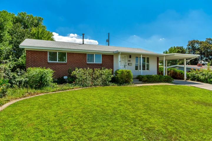 Brick and white siding exterior with a carport and front yard