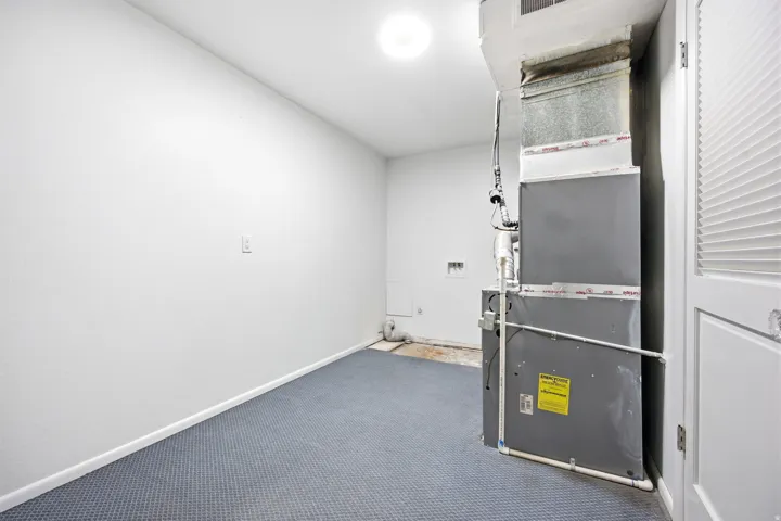 Large laundry room with extra storage and HVAC system.