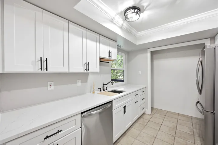 Kitchen featuring white shaker-style cabinetry and counter space.