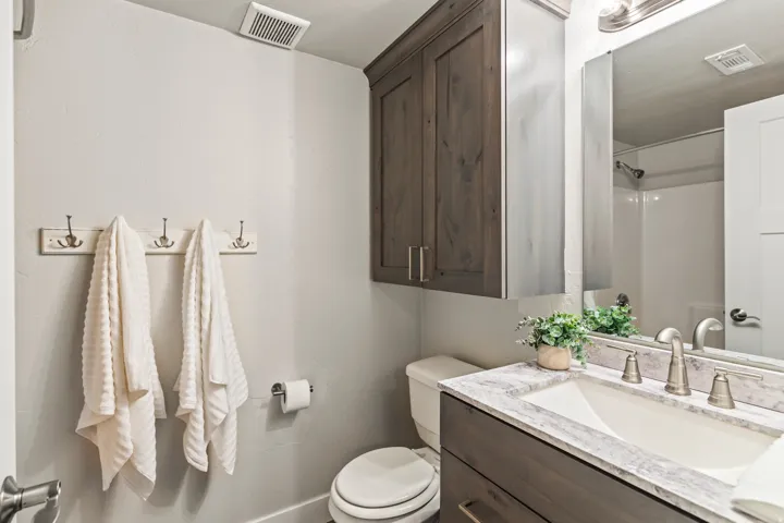 Vanity with an integrated white sink, brushed nickel faucet, and a stone-finish countertop