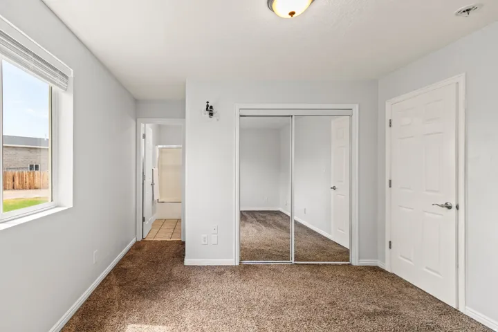 Room featuring neutral-toned carpeting, light gray wall finishes, and white trim