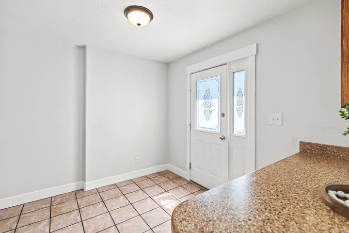 Entryway featuring a white door with decorative glass inserts and a coordinating sidelight
