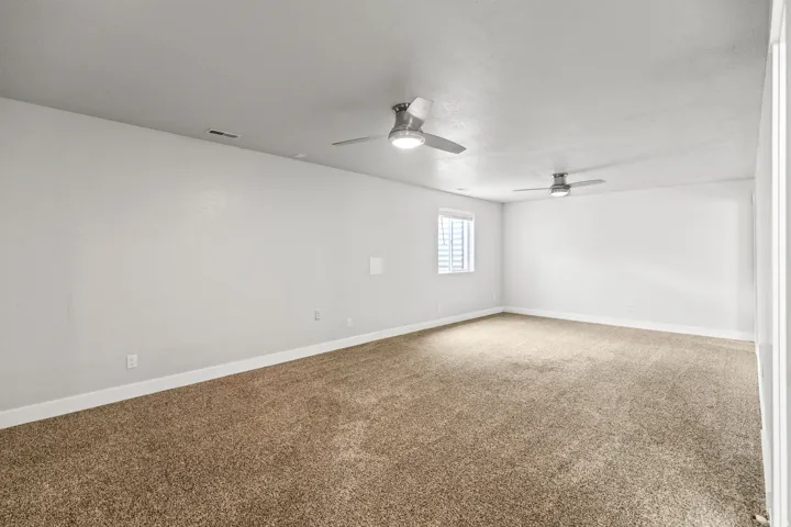Spacious room featuring neutral carpeting and white wall finishes