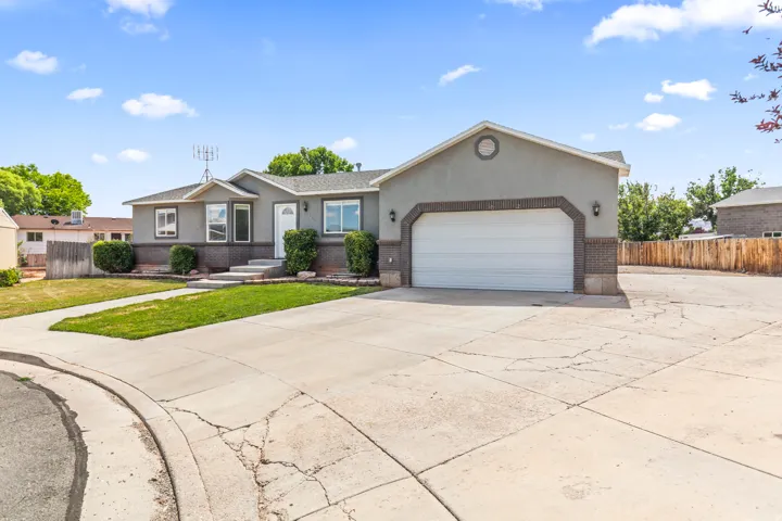 Ranch-style exterior featuring a two-car garage, brick accents, and a gabled roofline