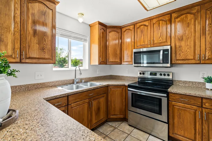 Kitchen featuring wood cabinetry, speckled countertops, a stainless steel range, and an over-the-range microwave