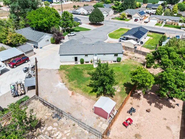 Ranch-style residence featuring a prominent front lawn with mature trees and a fenced backyard