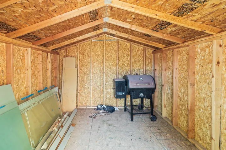 Interior shed featuring exposed wood framing and oriented strand board walls and ceiling